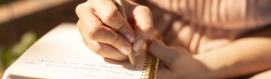 close-up-hand-writing-notebook